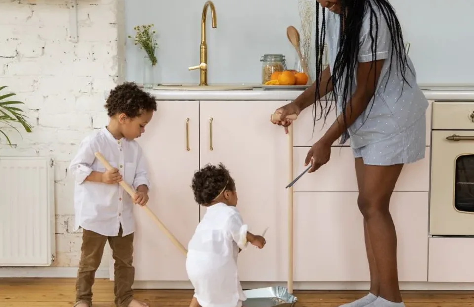 Parent and children working through a kitchen chore together